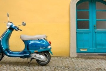 a blue scooter parked infront of a building